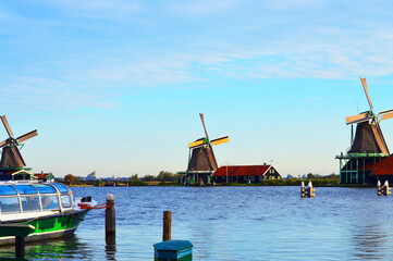 Three windmills by the river in The Netherlands