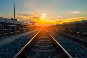 Fototapeta na wymiar Railroad tracks and the orange light of the sunset