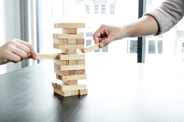 Two hands playing blocks wood game, gambling placing wooden block. Concept Risk of management and strategy plan, growth business success process, and teamwork
