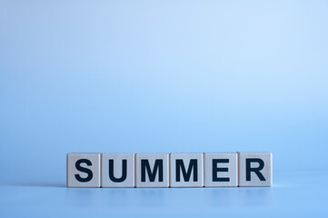 Summer. Black letters on wooden cubes. On a blue background