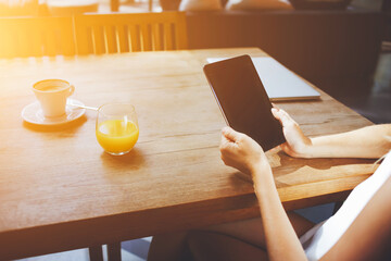 Closely image of woman's hands holding touch pad with blank copy space screen for your advertising text message or content, young female watching video on digital tablet while waiting friends in cafe