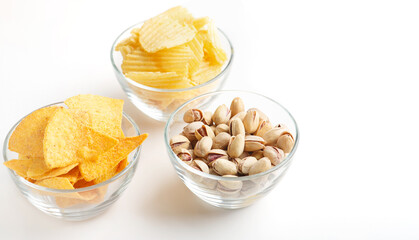 Snacks for friends company. Pistachio, chips and nachos in glass plate