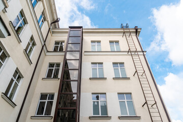 Fototapeta na wymiar Glass elevator on a house facade