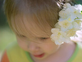 Obraz na płótnie Canvas Portrait of a little cute girl with a jasmine flower in her hair