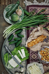 Still life with homemade milk cheese vegetables and herbs. The view from the top.