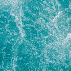 Turquoise green sea water with bubbles, abstract texture nature background