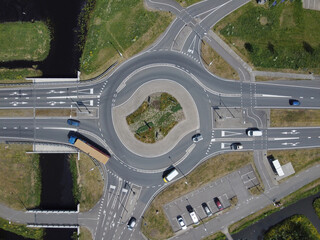 Aerial top down view of a traffic roundabout on a main road in an urban area