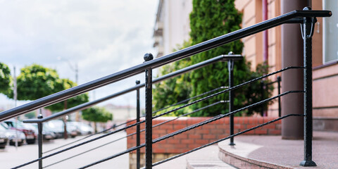 black iron railing on staircase with marble steps near hotel entrance at city street