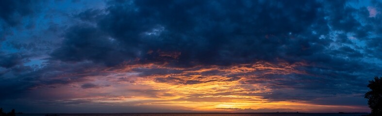Naklejka na ściany i meble Beautiful sunset with colored clouds over the sea