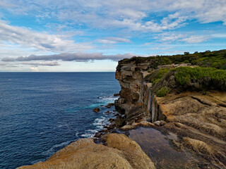Beautiful coastal trail with colorful rock formations near Wattamolla Beach, Royal National Park, New South Wales, Australia
