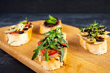 Bruschetta with chicken liver paste. Delicious bruschettas with various fillings. Different bruschetta ob wooden background
