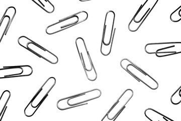 Many silver paper clips isolated on white studio background. Paper clip background / texture
