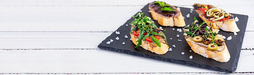 Bruschetta with chicken liver paste. Delicious bruschettas with various fillings. Different bruschetta ob wooden background