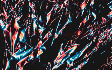 Colorful abstract background. Crashed texture. Blue orange wrinkled foil on black dust surface.