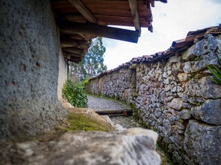 Brick pathway surrounded by old stone walls with shelters at daytime