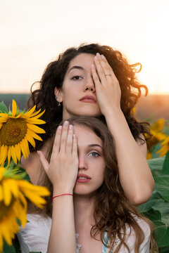 Beautiful young girls posing at sunset in a sunflower field 