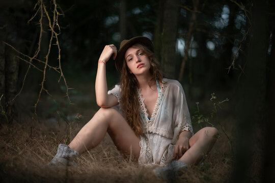 Beautiful young girl wearing a lace top posing in a dark forest