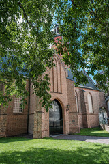 Naklejka premium View of Sint Lambertuskerk protestant church in small town Buren, Gelderland, the Netherlands. Sunny summer day with blue sky with clouds. July 2020