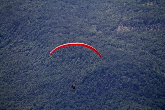 Closeup shot of red paraplane on a background of foliage mountain