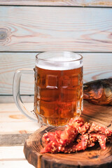 Mug with beer and snacks on a background of a brick wall on the table. The concept of relaxation, bars and parties