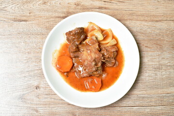 fried pork bone with slice carrot and onion with swet and sour sauce on plate