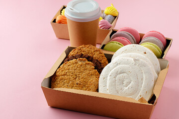 Carton box with oat cookies on pink table