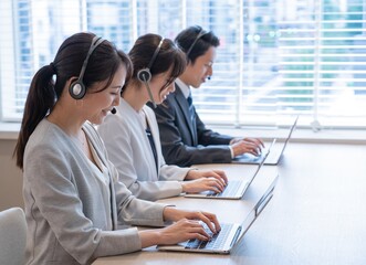 ヘッドホンをつけた　アジア人　営業　テレアポ