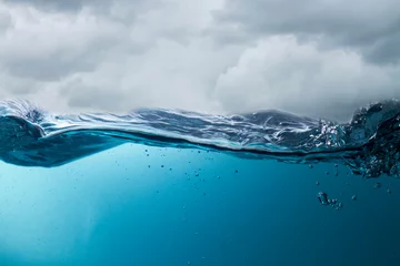 Fototapete The deep blue sea at the time of the storm can be seen from under the water. Abstract wave blur under water © Montri