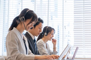 ヘッドホンをつけた　アジア人　営業　テレアポー