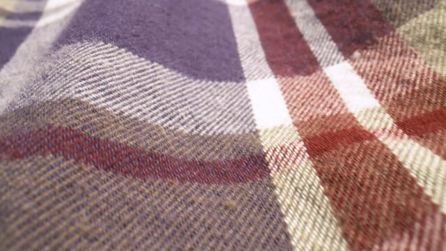 Close up slide across the fabric of a plaid shirt.