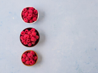 Assorted fresh raspberry in different plates.