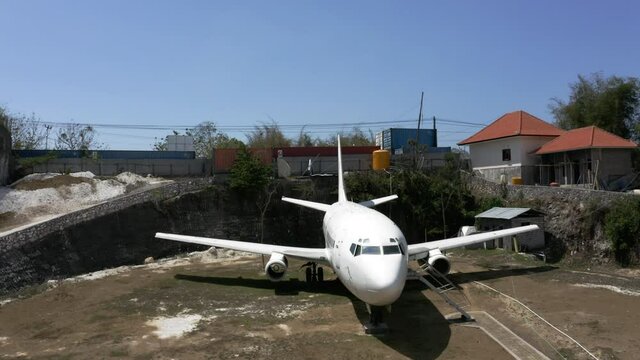 The mysterious abandoned jet airplane in a residential area on the island of Bali, aerial 