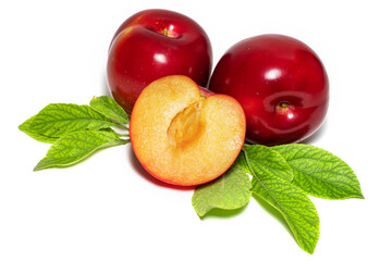 Plum fruits with green leaves and slice isolated on white