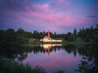 The famous Priory Palace during sunset, with colorful clouds under sunlight. Fairytale Castle in Gatchina, Russia. Popular photography locations. Ideas for travels, postcard