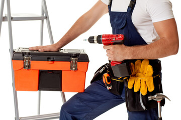 repairman holding cordless screwdriver and tool box. handyman with working tools on belt