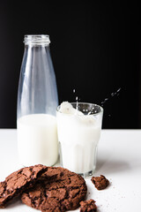 pouring milk in glass with chocolate cookies