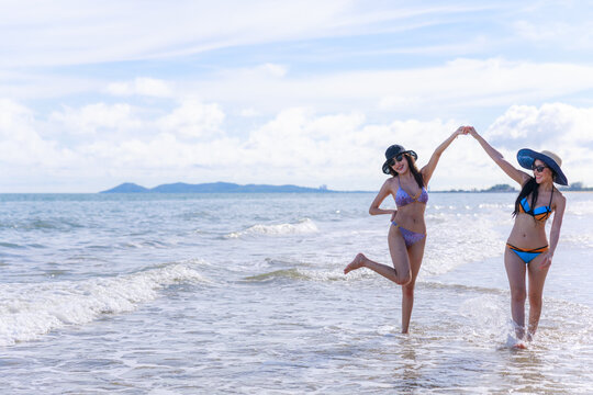 Two asian female walking relaxation on the beach.