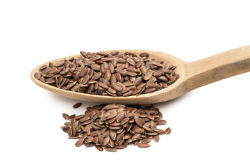 Close up of linseed or flax seeds on a wooden spoon with a pile next to it seen from the side and isolated on white background