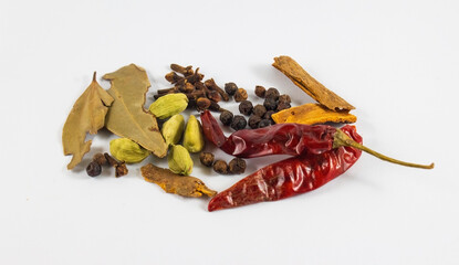 Spices on white background, cardamom, red chili, bay leaf, cloves, cinnamon, black pepper