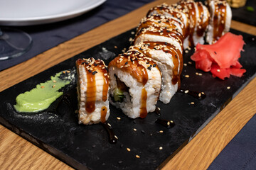 Sushi rolls with wasabi sauce on the table in the restaurant. Japanese national cuisine, seafood and fish.