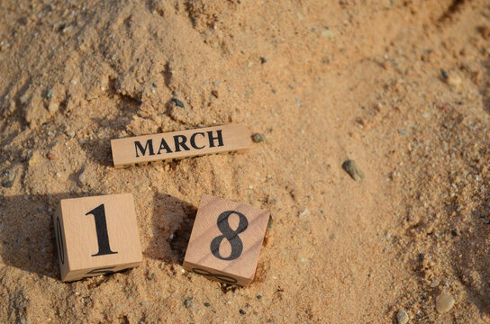 March 18, Number cube with Sand pile for a background.
