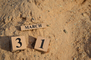 March 31, Number cube with Sand pile for a background.
