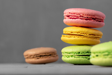 Colorful macaroon cookies on grey surface close up