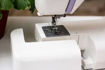 White sewing machine top view. Sewing machine threaded.