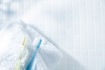 歯ブラシが2本とタオル。歯磨きなど歯のケア、生活・日常のイメージ。