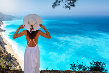 Sommer Touristin mit weißem Hut schaut auf den schönen Strand von Egremni auf der Insel Lefkada,...