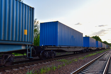 Cargo Containers Transportation On Freight Train By Railway. Intermodal Container On Train Car. Rail Freight Shipping Logistics Concept. Import - export goods from Сhina. Motion, Out of focus
