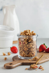 Homemade granola in a glass jar with fresh strawberries. The concept of a quick Breakfast, a healthy diet. Copy space.