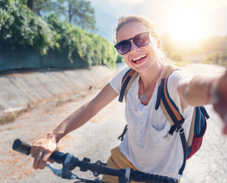Girl with a bicycle makes selfie on a smartphone. Summer vacation and travel by bicycle, sports and outdoor activities