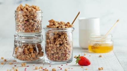 Banner with homemade granola in different glass jars with strawberries, honey. concept of a Breakfast, a healthy diet.